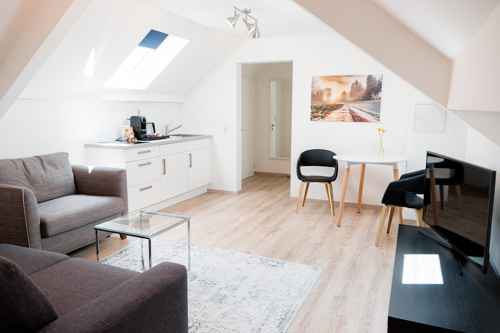 Living room with kitchenette in all hotel suites at Apex Nürburg.